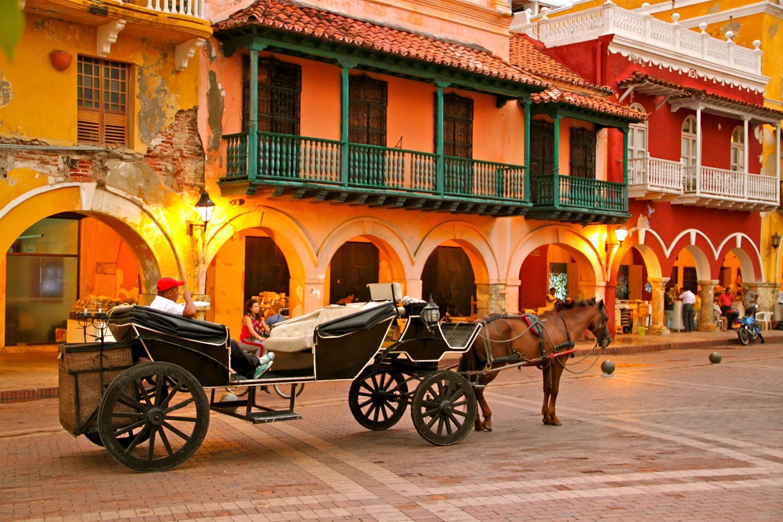 Horse-drawn carriage in front of colonial buildings with wooden balconies and arcades in Cartagena's old city