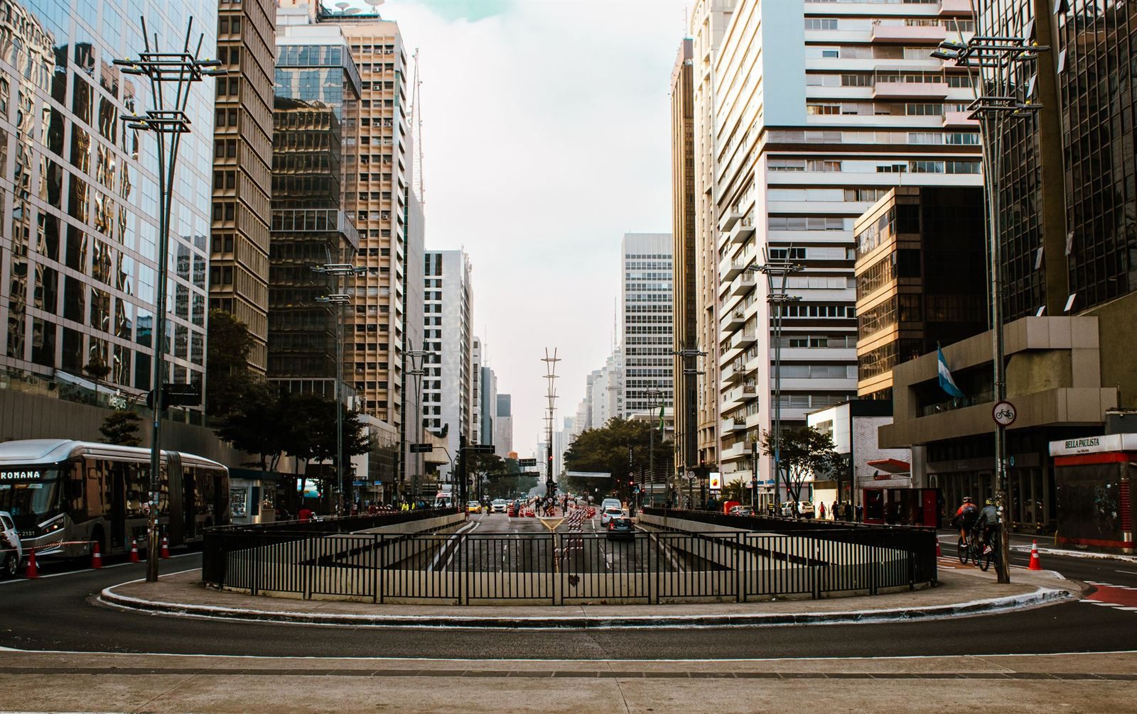 Office towers lining a wide avenue in central São Paulo with a city bus and light traffic