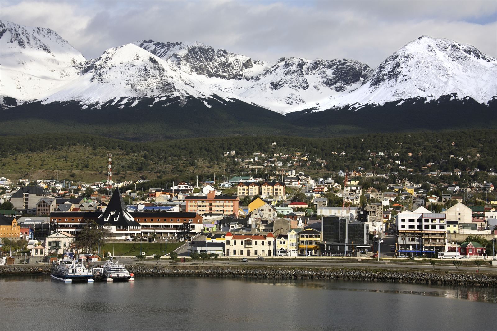 Ushuaia town and harbor boats on the Beagle Channel below snow-covered mountains