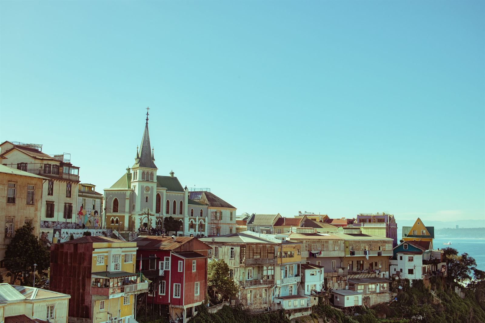 Colorful hillside houses and a church spire above the bay in Valparaíso